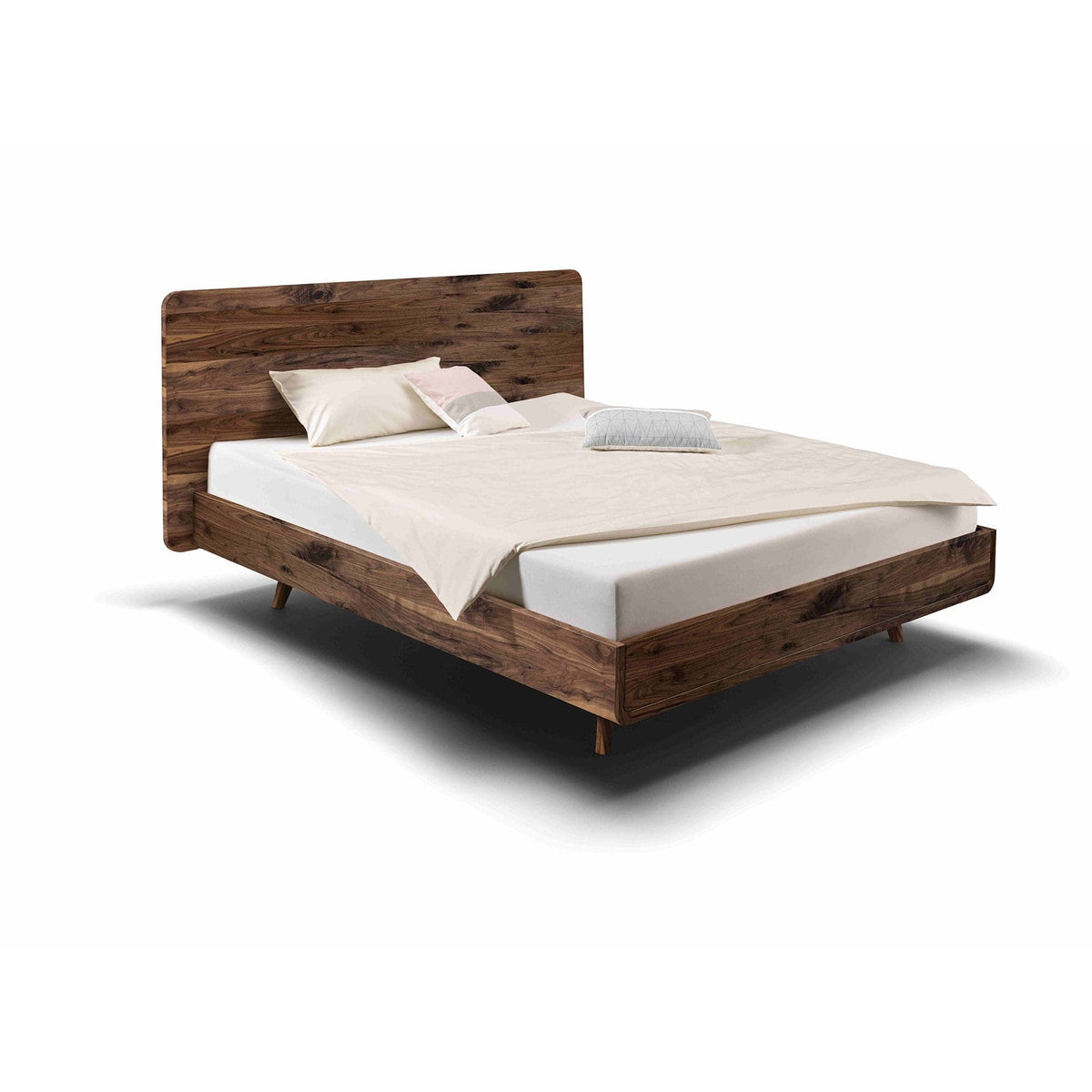 Bett TALOS der Holzmanufaktur aus wildem Nussbaum mit hohem Holzkopfteil im Boxspring Look.