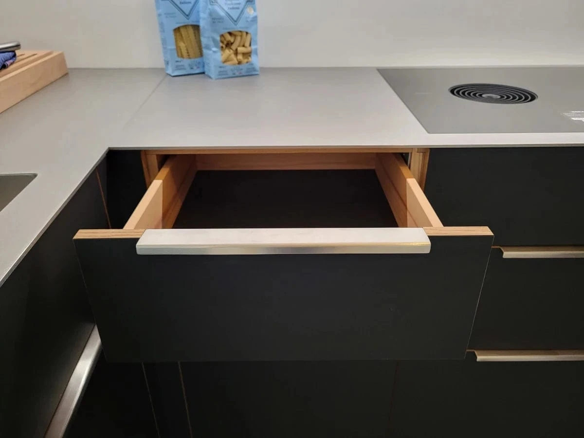 Schwarze Küchenfront mit Kanten aus massivem Wildeiche-Holz und Edelstahl-Griffprofilen