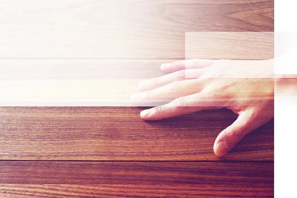 Pflegende Hand auf Massivholz
